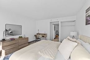 Fayetteville apartment for rent - A bedroom with a large bed and a desk with a chair.