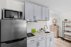 Burlington apartment for rent - A modern kitchen with a stainless steel refrigerator and white cabinets.