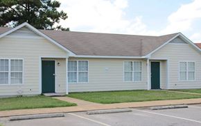 Fayetteville apartment for rent - A two-story house with a green door and a driveway in front.