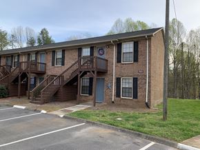 Winston Salem apartment for rent - A brick building with a blue star on the door and a red and white sign on the window.
