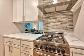 Norfolk apartment for rent - A modern kitchen with a stainless steel gas stove and white cabinets.