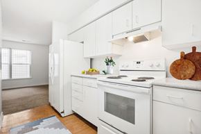 Durham apartment for rent - A white kitchen with a refrigerator, oven, and stove.