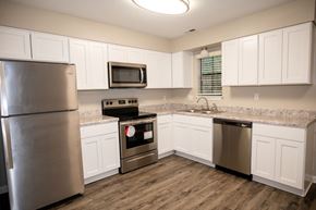 Apex townhouse for rent - A kitchen with a stainless steel refrigerator, microwave, oven, and dishwasher.