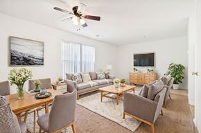 Durham apartment for rent - A living room with a grey couch, a wooden table, and a ceiling fan.