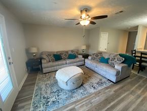 Fayetteville apartment for rent - A living room with a white ceiling fan and two couches.
