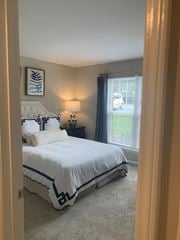 Morrisville apartment for rent - A bedroom with a large bed and a window with a view of a parking lot.