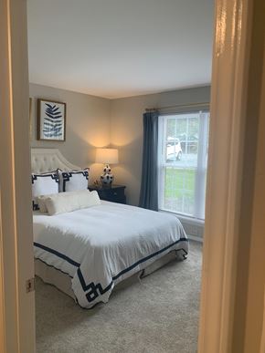 Morrisville apartment for rent - A bedroom with a large bed and a window with a view of a parking lot.