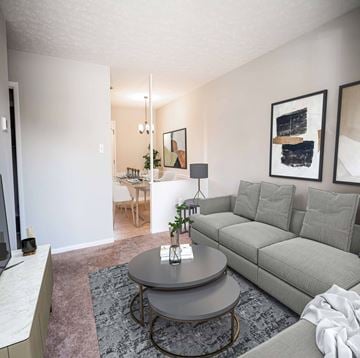 Fayetteville apartment for rent - A grey couch sits in a living room with a table in front of it.