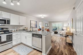 Winston-Salem townhouse for rent - A kitchen with white cabinets and a patterned rug on the floor.