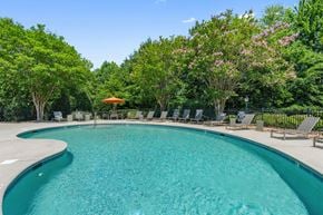 Winston-Salem townhouse for rent - A swimming pool surrounded by trees and chairs.