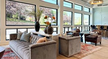 Asheville apartment for rent - A living room with a grey couch and a brown armchair.