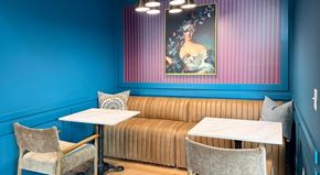 Asheville apartment for rent - A dining area with a blue wall and a painting above a sofa.