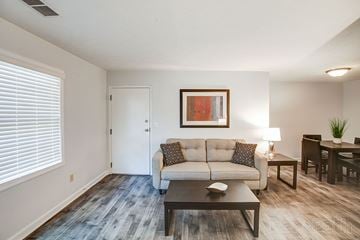 Fayetteville apartment for rent - A living room with a couch, coffee table, and a painting on the wall.
