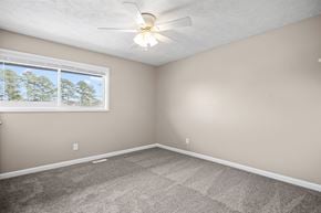 Fayetteville townhouse for rent - A room with a ceiling fan and a window showing trees outside.