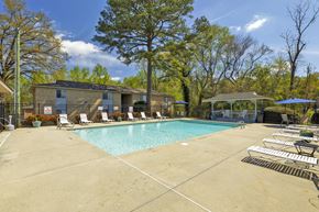 Fayetteville apartment for rent - A swimming pool surrounded by trees and chairs.