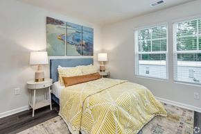 Myrtle Beach apartment for rent - A bedroom with a bed, two lamps, and a painting on the wall.