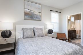 Jacksonville apartment for rent - A bedroom with a large bed and a painting on the wall.