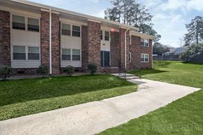 Fayetteville apartment for rent - A brick building with a white door and windows.