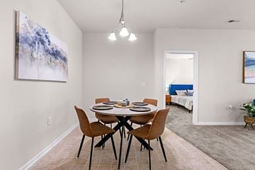 Fayetteville apartment for rent - A dining room with a table set for four and a painting on the wall.