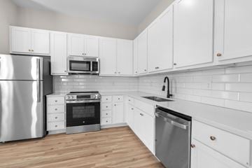 Kernersville apartment for rent - A kitchen with white cabinets and a stainless steel refrigerator.