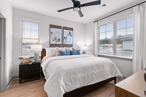 Fayetteville townhouse for rent - A bedroom with a large bed and a ceiling fan.