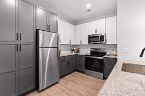 Fayetteville townhouse for rent - A modern kitchen with a stainless steel refrigerator and microwave above the oven.