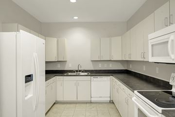 Durham apartment for rent - A white kitchen with a refrigerator on the left.