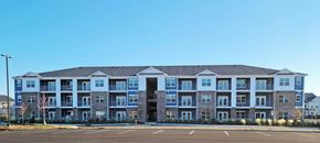 Kernersville apartment for rent - A large apartment building with a parking lot in front.