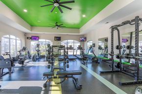 Jacksonville apartment for rent - A gym with a variety of equipment including treadmills, weights, and exercise machines.
