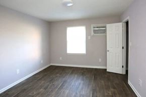 Greensboro apartment for rent - an empty living room with wood floors and a white door