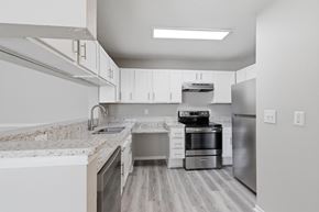 Winston Salem apartment for rent - A modern kitchen with stainless steel appliances and white cabinets.