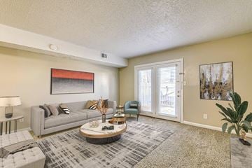 Fayetteville apartment for rent - A living room with a grey couch, a coffee table, and a painting on the wall.