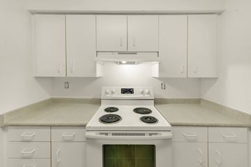 Durham apartment for rent - A white stove in a kitchen with white cabinets.