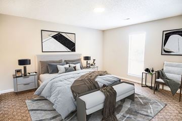 Fayetteville apartment for rent - A bedroom with a large bed and a chair.