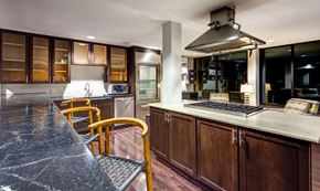 Norfolk apartment for rent - A modern kitchen with dark wood cabinets and a marble countertop.