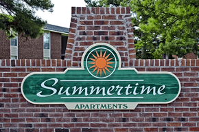 Fayetteville apartment for rent - A sign for Summertime Apartments is mounted on a brick wall.
