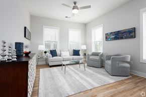 Kernersville apartment for rent - A living room with a white couch, a grey armchair, and a coffee table.