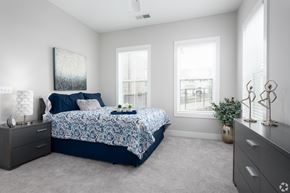 Kernersville apartment for rent - A bedroom with a bed, nightstands, and a plant.