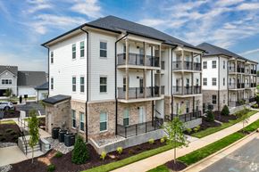 Kernersville apartment for rent - A row of modern apartment buildings with balconies and landscaped front yards.