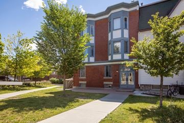 Ottawa apartment for rent - A red brick building with a green tree in front.