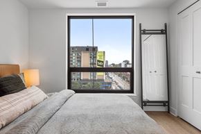 Ottawa apartment for rent - a bedroom with a large window and a bed