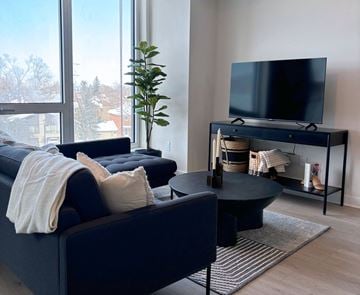 Ottawa apartment for rent - A living room with a dark blue sofa and a black coffee table.
