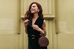 Ottawa apartment for rent - a woman in a black dress holding a brown purse and smiling