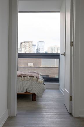 Ottawa apartment for rent - A bedroom with a bed and a view of the city.