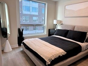 Ottawa apartment for rent - A bedroom with a large bed and a large window.