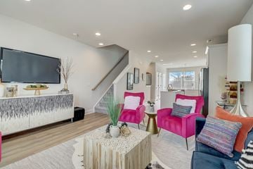 Charlotte townhouse for rent - A living room with a white sofa and a pink armchair.