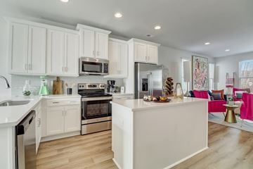 Charlotte townhouse for rent - A modern kitchen with white cabinets and stainless steel appliances.