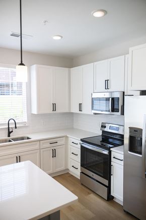 Hickory townhouse for rent - a kitchen with white cabinets and stainless steel appliances at Landon Green Artisan Cottages Apartments, North Carolina