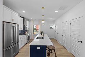 Charlotte townhouse for rent - a large kitchen with white cabinets and stainless steel appliances at The Collection Charlotte in Charlotte, NC, 28205