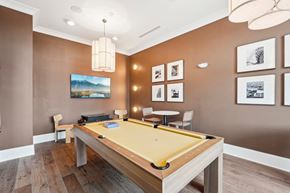 Cornelius apartment for rent - A pool table is in the middle of a room with brown walls.
